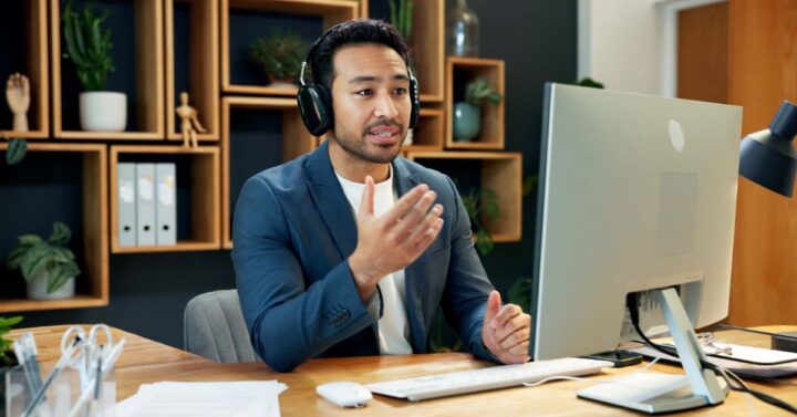 Professional using a headset and webcam for a remote video meeting